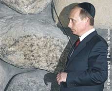 Путин в кипе (ермолке) внимательно нюхает куриный навоз