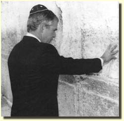 Obediently wearing his Jewish skull cap, then Governor George Bush
		prays at the wailing wall of the Jews in Jerusalem